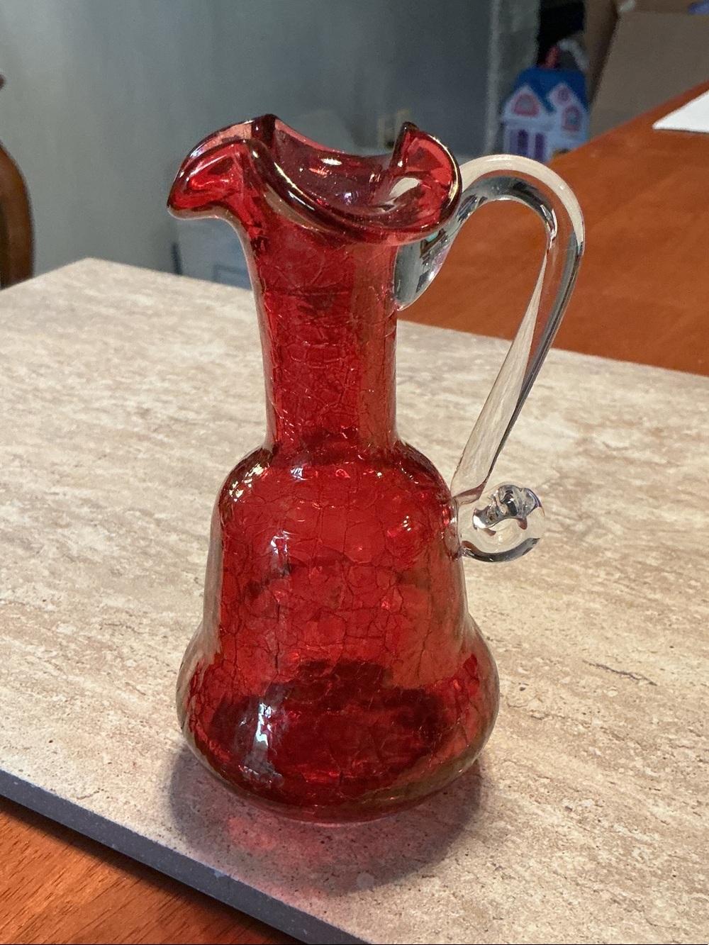 Vintage ruby red crackle glass pitcher with clear glass handle.